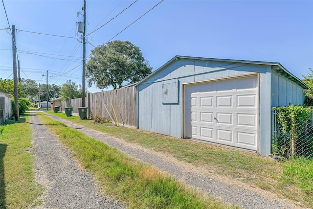detached garage with driveway and fence
