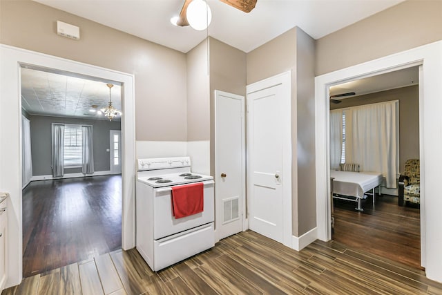 kitchen featuring dark wood-style floors, white range with electric stovetop, light countertops, visible vents, and baseboards