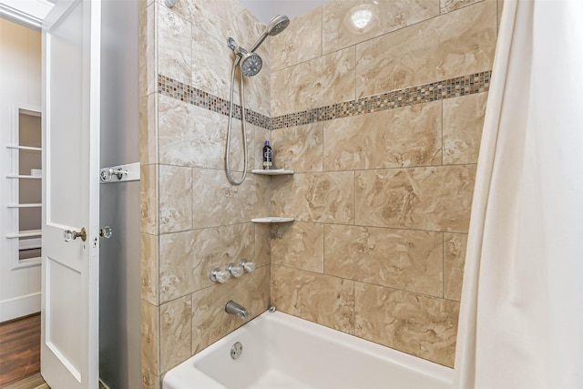 bathroom featuring wood finished floors and shower / bathtub combination with curtain