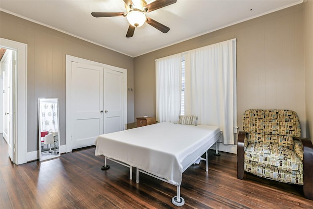 bedroom featuring wood finished floors, a closet, crown molding, and a ceiling fan