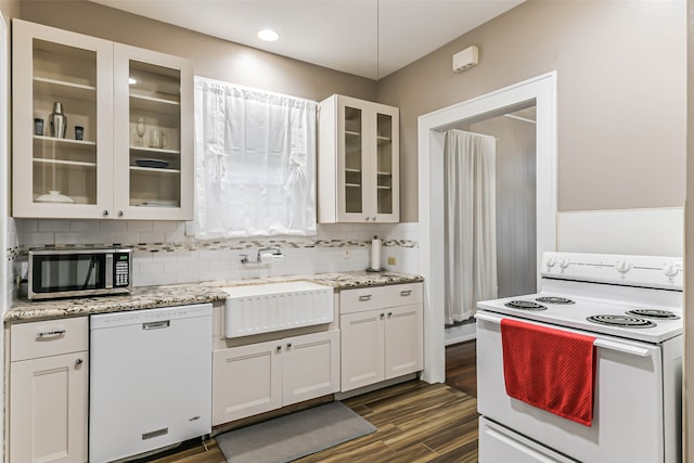 kitchen with decorative backsplash, white cabinetry, white appliances, dark hardwood / wood-style floors, and sink