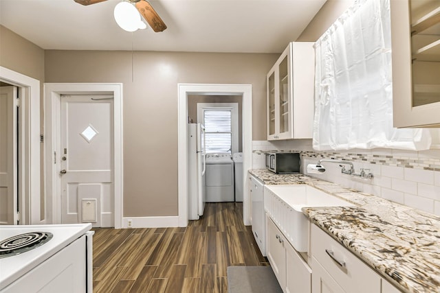 kitchen with tasteful backsplash, washer and dryer, ceiling fan, dark wood finished floors, and white cabinetry