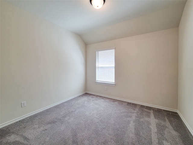 empty room with carpet floors and lofted ceiling