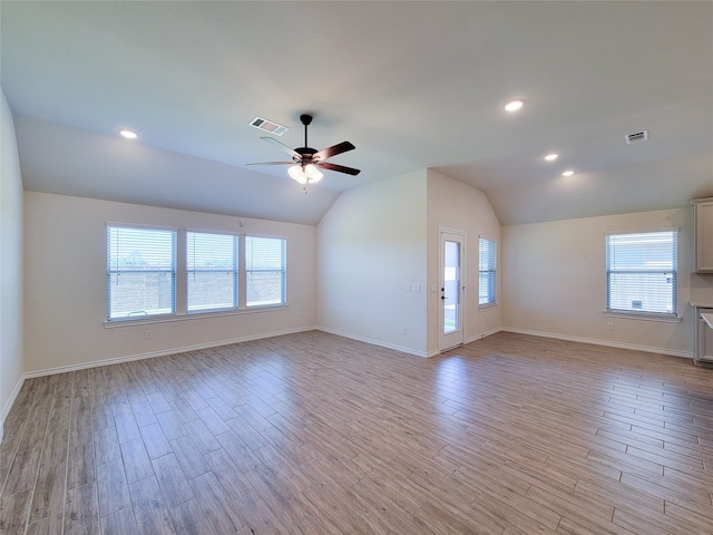 unfurnished living room with light hardwood / wood-style flooring, vaulted ceiling, ceiling fan, and a healthy amount of sunlight