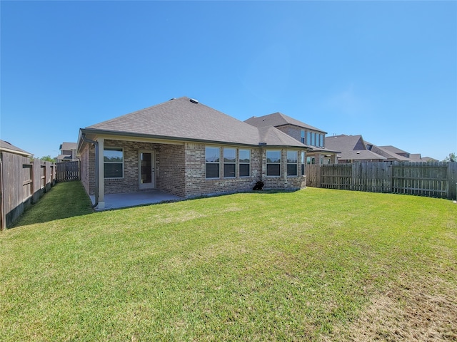 rear view of property with a lawn and a patio area