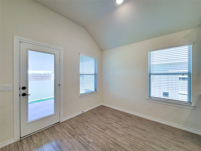 entryway with light hardwood / wood-style floors and vaulted ceiling