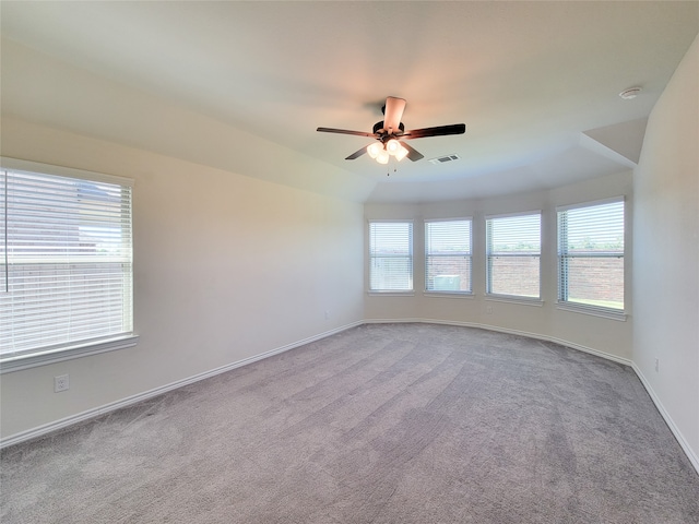 carpeted spare room with ceiling fan and plenty of natural light