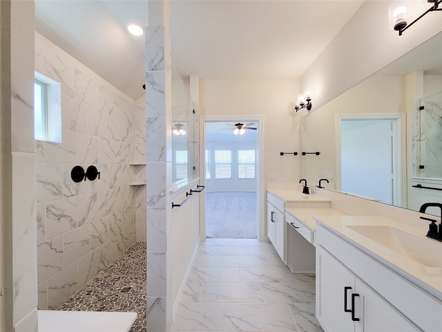 bathroom featuring a tile shower, a wealth of natural light, ceiling fan, and vanity