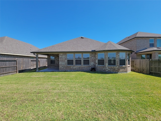 rear view of property with a yard and a patio area