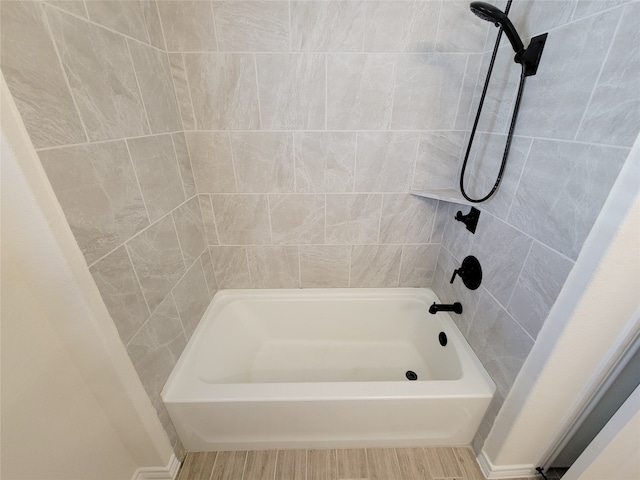 bathroom featuring tiled shower / bath combo and hardwood / wood-style floors