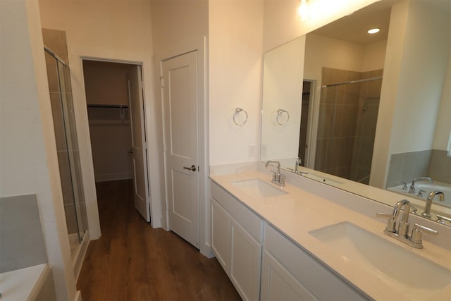 bathroom featuring wood-type flooring, vanity, and a shower with shower door