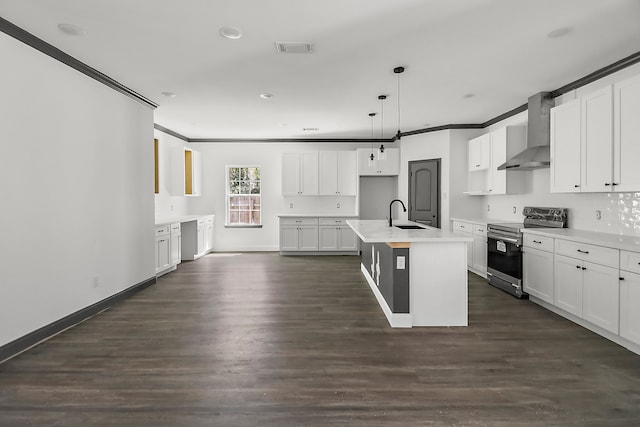 kitchen with pendant lighting, an island with sink, wall chimney exhaust hood, stainless steel appliances, and dark hardwood / wood-style floors