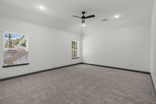 carpeted spare room featuring a wealth of natural light and ceiling fan