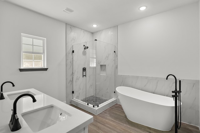 bathroom featuring vanity, plus walk in shower, tile walls, and hardwood / wood-style flooring