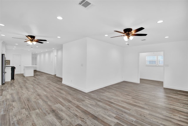 unfurnished living room featuring ceiling fan and light hardwood / wood-style floors