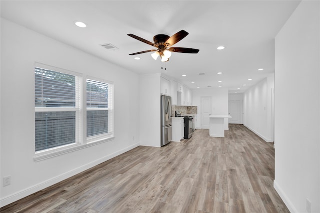 unfurnished living room with light hardwood / wood-style flooring and ceiling fan