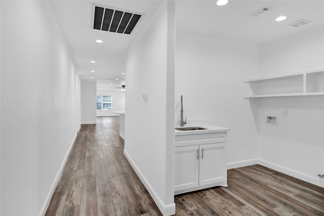 hallway with hardwood / wood-style floors and sink