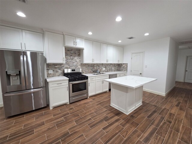 1307 Brooks Ave, Rosenberg, TX 77471 - kitchen featuring appliances with stainless steel finishes, a sink, backsplash, white cabinets, and dark wood-style flooring
