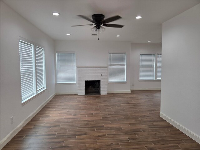 1307 Brooks Ave, Rosenberg, TX 77471 - unfurnished living room featuring a ceiling fan, dark wood-style flooring, recessed lighting, baseboards, and a fireplace