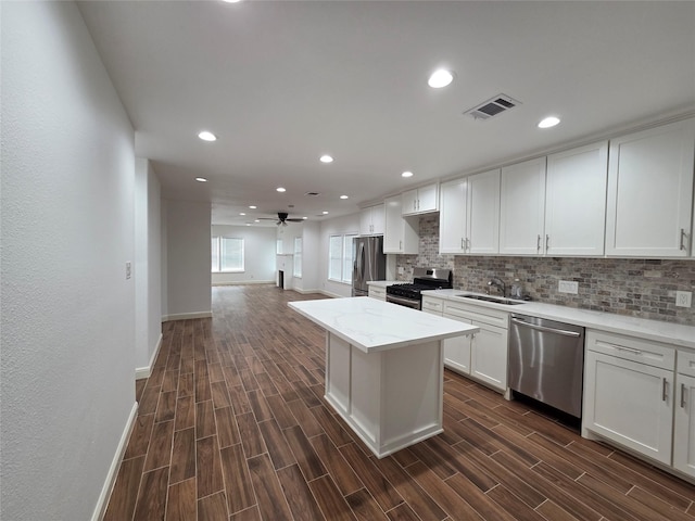 1307 Brooks Ave, Rosenberg, TX 77471 - kitchen with stainless steel appliances, a sink, dark wood-style flooring, tasteful backsplash, and baseboards