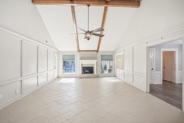 unfurnished living room with light tile patterned flooring, a brick fireplace, ceiling fan, beamed ceiling, and high vaulted ceiling