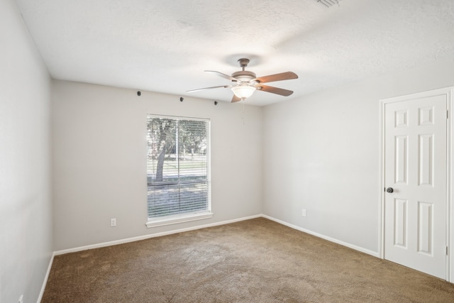 unfurnished room featuring a textured ceiling, carpet, and ceiling fan