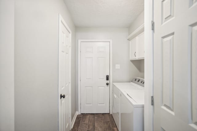 laundry area with a textured ceiling, cabinets, washer and clothes dryer, and dark hardwood / wood-style floors