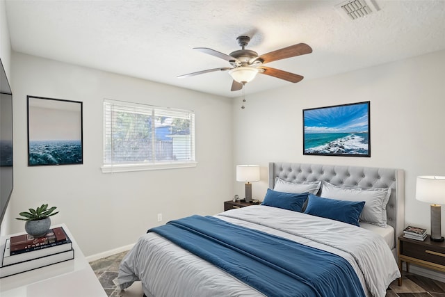 bedroom featuring ceiling fan and a textured ceiling