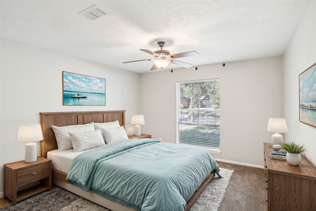 carpeted bedroom with ceiling fan and a textured ceiling