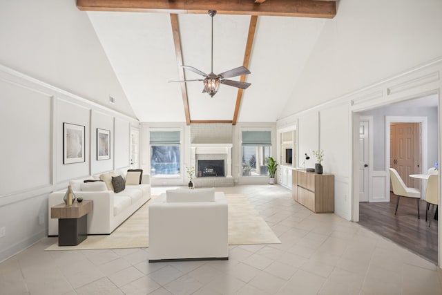 living room with light tile patterned flooring, a brick fireplace, ceiling fan, beam ceiling, and high vaulted ceiling