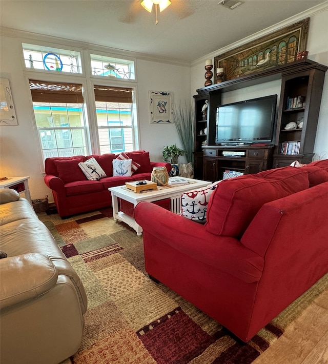 living room featuring crown molding, ceiling fan, and a wealth of natural light