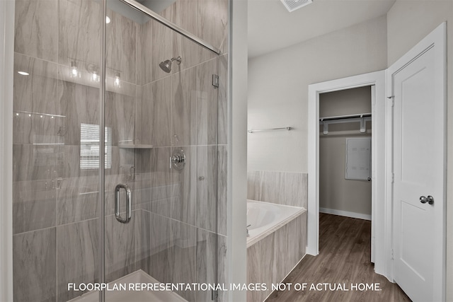 bathroom with independent shower and bath and hardwood / wood-style flooring