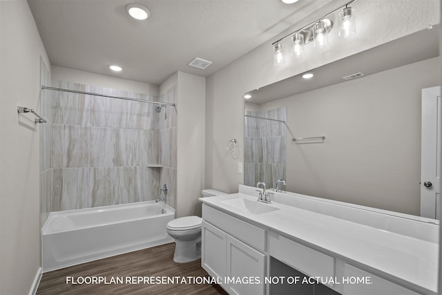 full bathroom with toilet, tiled shower / bath combo, hardwood / wood-style flooring, a textured ceiling, and vanity