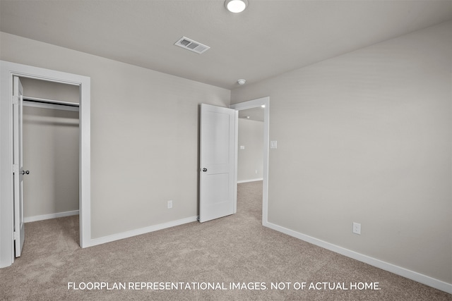 unfurnished bedroom featuring light colored carpet and a closet