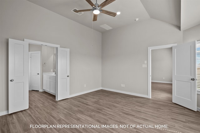 unfurnished bedroom with lofted ceiling, ceiling fan, light wood-type flooring, and connected bathroom