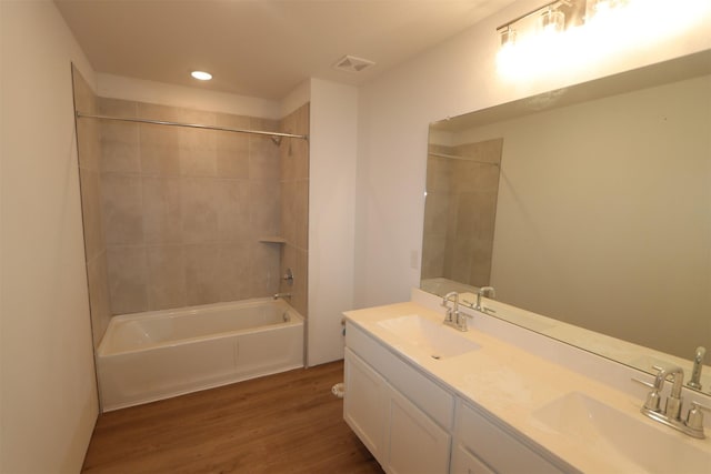 bathroom featuring hardwood / wood-style flooring, vanity, and tiled shower / bath