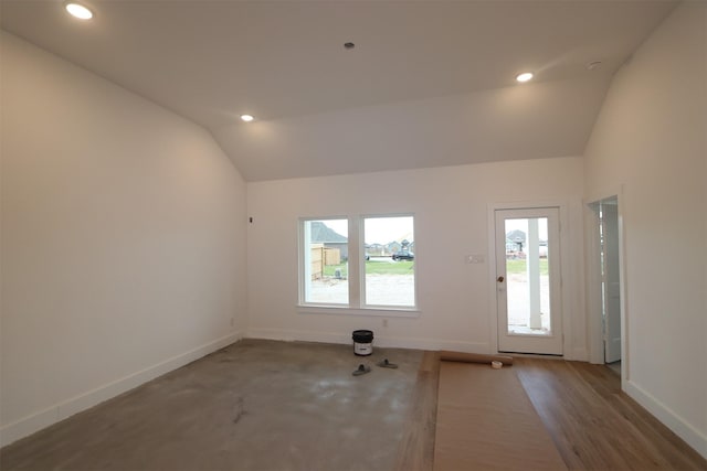 unfurnished room featuring vaulted ceiling and hardwood / wood-style floors