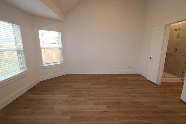 spare room featuring lofted ceiling and dark hardwood / wood-style floors