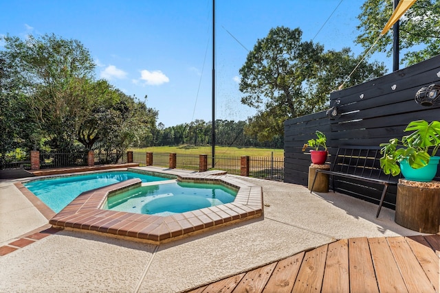 view of swimming pool with an in ground hot tub