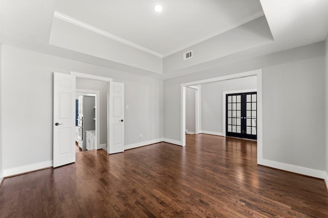 spare room featuring french doors, dark hardwood / wood-style flooring, a tray ceiling, and ornamental molding