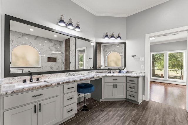 bathroom with a shower, vanity, and ornamental molding