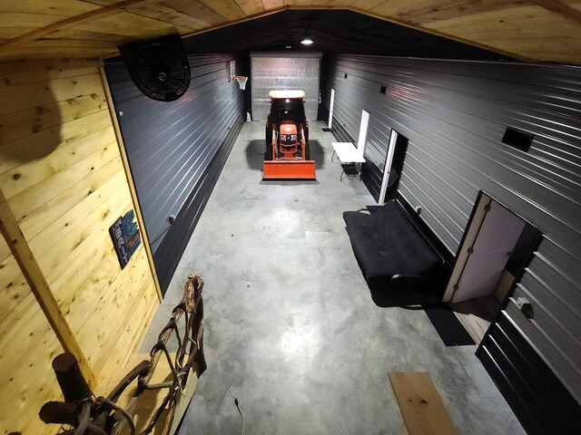 interior space featuring wooden walls, concrete flooring, and wood ceiling