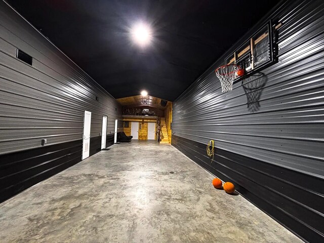 corridor featuring concrete floors and wooden walls