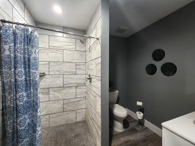 bathroom featuring a shower with curtain, hardwood / wood-style floors, and toilet