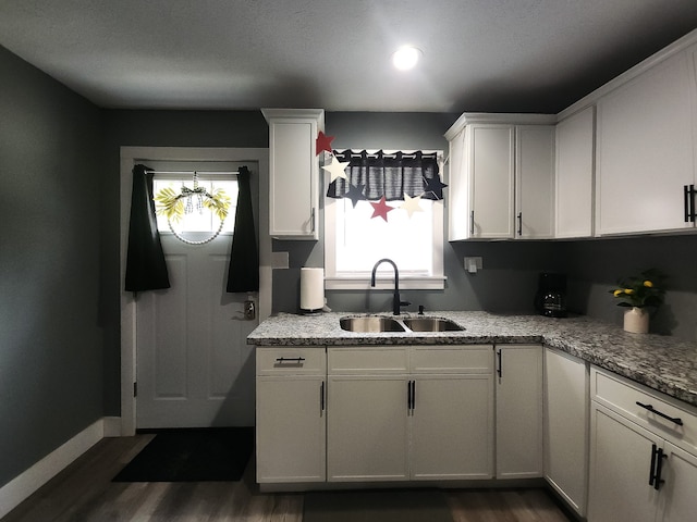 kitchen featuring dark wood-type flooring, sink, white cabinetry, and a wealth of natural light