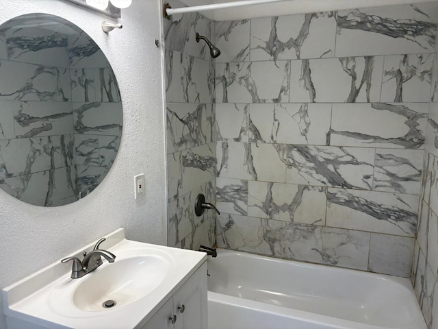 bathroom with tiled shower / bath combo and vanity