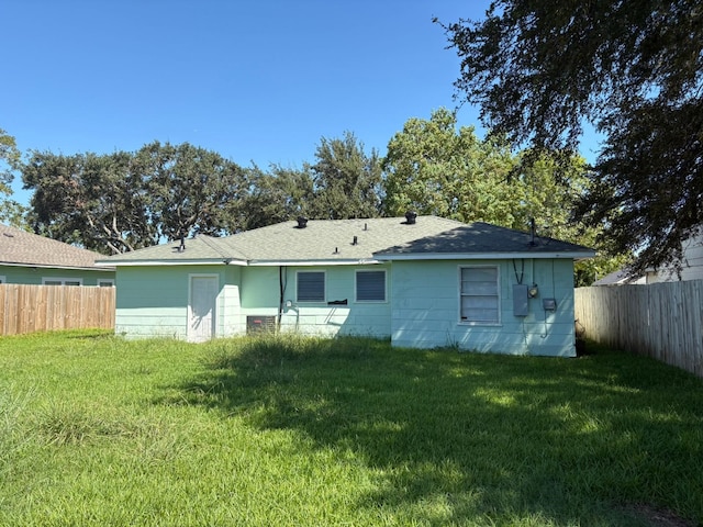 rear view of property with a yard