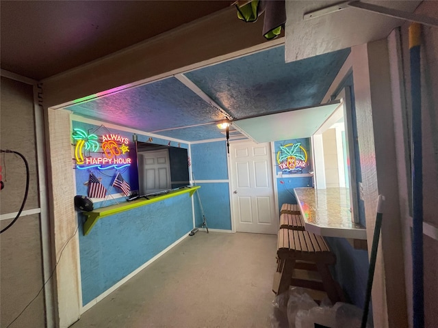game room with concrete floors and a textured wall