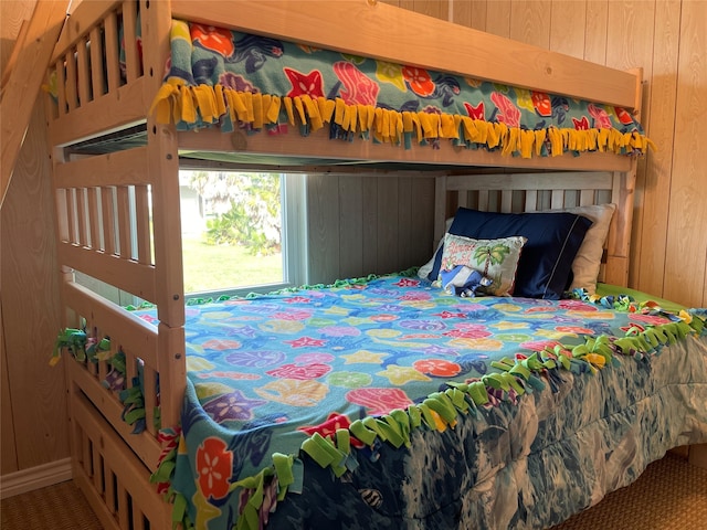 bedroom featuring carpet and wood walls