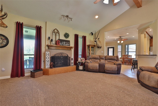 living room with carpet flooring, beam ceiling, ceiling fan, and high vaulted ceiling